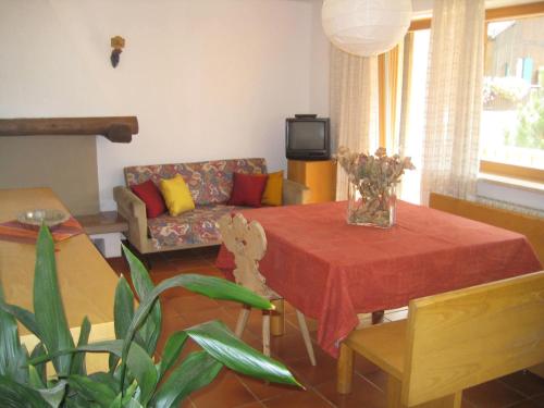 a living room with a table and a couch at Appartamenti Decrestina in Campitello di Fassa