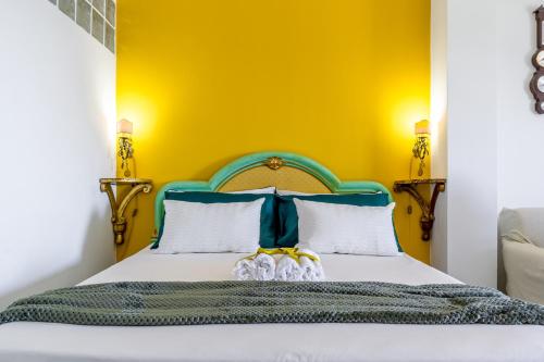 - une chambre dotée d'un lit avec un mur jaune dans l'établissement Brezza di Mare, à Giardini Naxos