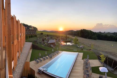 an outdoor swimming pool with a sunset in the background at Ratscher Landhaus in Ratsch an der Weinstraße