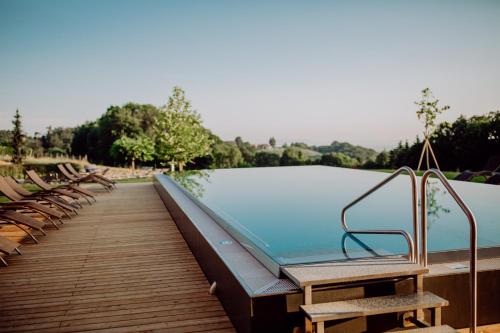 a swimming pool with chairs on a wooden deck at Ratscher Landhaus in Ratsch an der Weinstraße