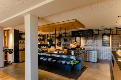 a restaurant with a counter with a person preparing food at Ratscher Landhaus in Ratsch an der Weinstraße