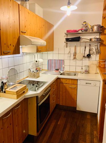 a kitchen with wooden cabinets and white appliances at PinkDeer in Hallstatt
