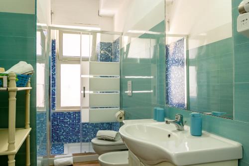 La salle de bains est pourvue d'un lavabo, de toilettes et d'un miroir. dans l'établissement Brezza di Mare, à Giardini Naxos