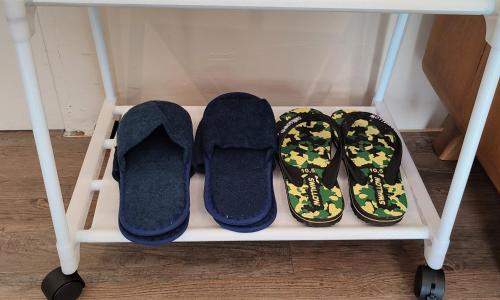 a pair of shoes and slippers on a shelf at Papilukas Room Kalibata City - Studio Gold in Jakarta