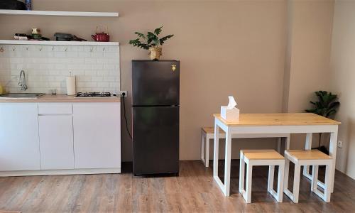 a kitchen with a black refrigerator and a table at Papilukas Room Kalibata City - Studio Gold in Jakarta