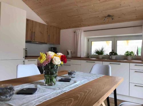 a vase of flowers on a table in a kitchen at Chiemsee Pferdehof Ferienwohnungen in Bernau am Chiemsee