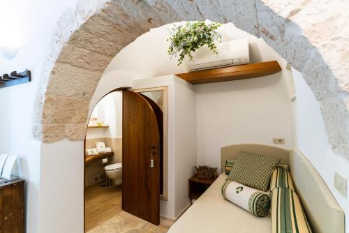 Habitación con arco y baño con aseo. en Palazzo Scotto, en Alberobello