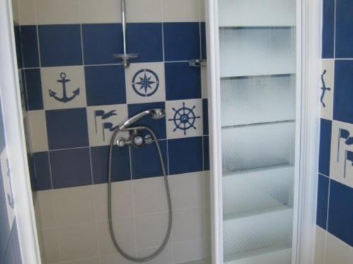 Villa de 250 m², climatisée, sur 2 niveaux au bord de l'eau - FR-1-100-243 في كافالير سور مير: حمام به دش وبه بلاط ازرق وابيض