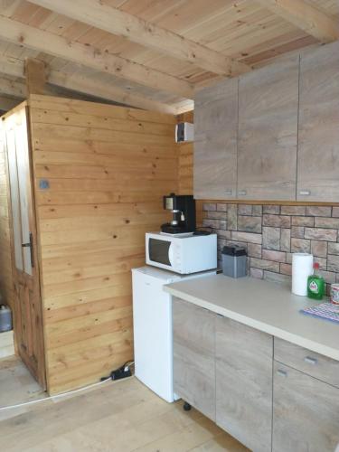 チェルノモレツにあるкаравана Марбеяの木製の壁、白い冷蔵庫付きのキッチン