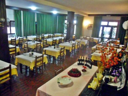 a dining room with tables and chairs and a large window at Albergo Giardino in Badia Prataglia