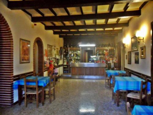 un restaurante con mesas y sillas azules y un bar en Albergo Giardino en Badia Prataglia