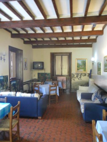 a living room with blue couches and a table at Albergo Giardino in Badia Prataglia
