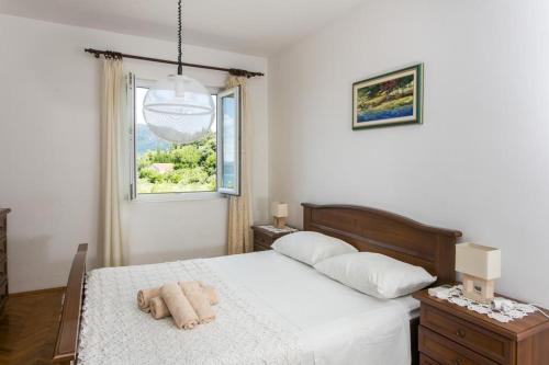 a bedroom with a bed with a stuffed animal on it at Apartments Maria in Koločep