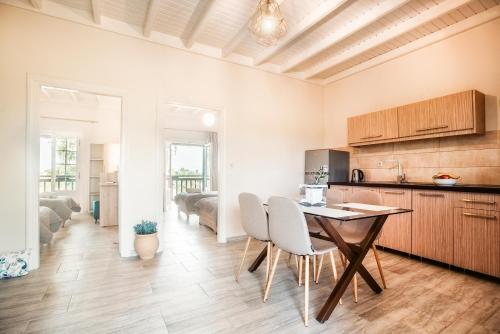 - une cuisine et une salle à manger avec une table et des chaises dans l'établissement Potamos Apartments, à Sidari
