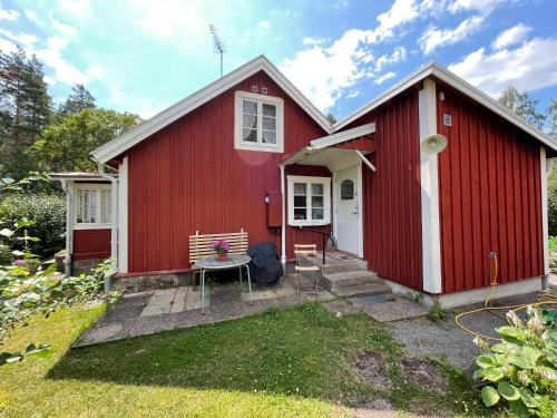une maison rouge avec un banc devant elle dans l'établissement Skruvshultkvarn, à Berga
