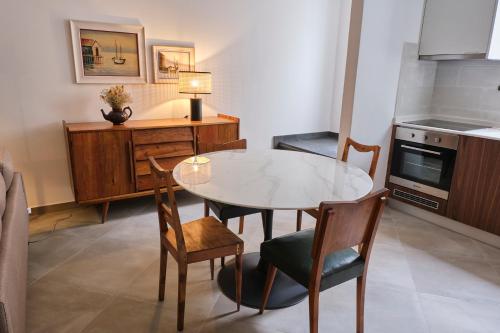 a small kitchen with a table and chairs in a room at Casas do Mercado - Casa Nautilo in Angra do Heroísmo