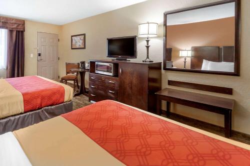 a hotel room with two beds and a flat screen tv at Econo Lodge Black Hills in Rapid City