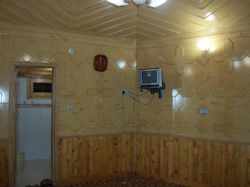 a room with a wall with a tv on it at Manila Huts in Naran