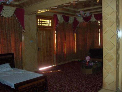 a bedroom with a bed in a room with curtains at Manila Huts in Nārān