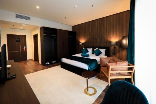 a hotel room with a bed and a chair at Premium Park Hotel in Prizren