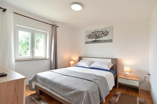 sypialnia z łóżkiem i drzewem na ścianie w obiekcie Apartments Fazana 407 w Fažanie