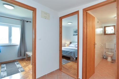 Pokój z łóżkiem i drzwiami prowadzącymi do sypialni w obiekcie Apartments Fazana 407 w Fažanie