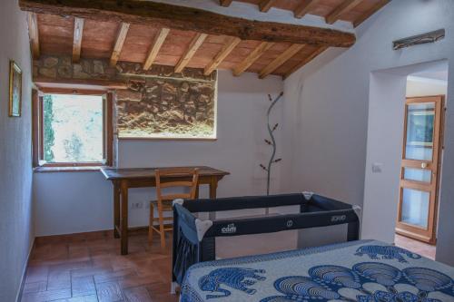 a bedroom with a bed and a desk and a table at ELBA Borgo di Latrano in Magazzini