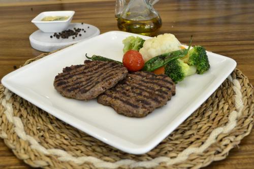 a plate of steak and vegetables on a table at Nobel Hotel in Mersin