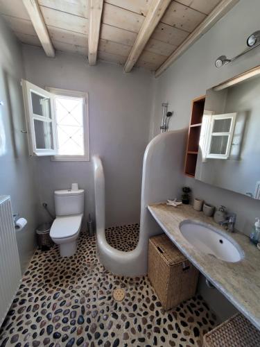 a bathroom with a toilet and a sink with a tub at Villa Elena in Ornos