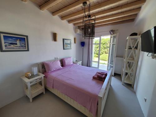 オルノスにあるVilla Elenaのベッドルーム1室(ピンクのシーツが敷かれたベッド1台、窓付)