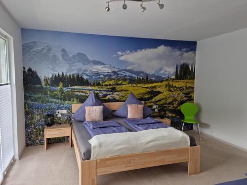 a bedroom with a bed with a mountain mural on the wall at Ferienwohnung Vier Pfoten in Willingen