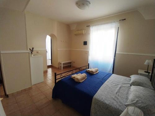 Un dormitorio con una cama azul con toallas. en Palma House en Catania