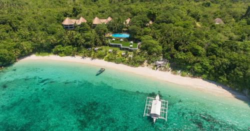 an aerial view of a beach with a boat in the water at Amun Ini Beach Resort & Spa in Anda