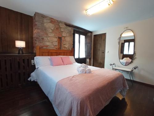 a bedroom with a bed with two stuffed animals on it at APARTAMENTOS RURALES LA GALERÍA in Ribota