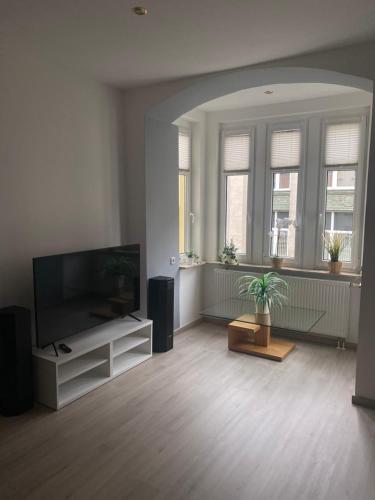 a living room with a flat screen tv and a table at Ferienwohnung mit Terrasse in Aue
