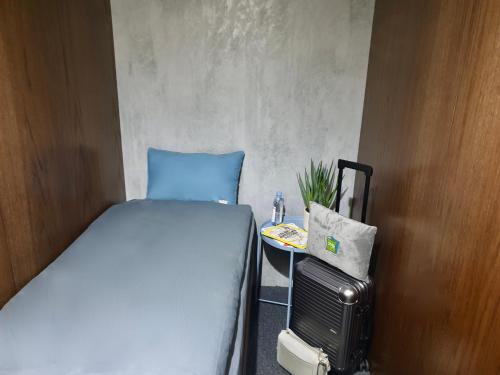 a small bedroom with a bed and a small table at sleep 'n fly Sleep Lounge & Showers, D-Gates Terminal 1 - TRANSIT ONLY in Dubai