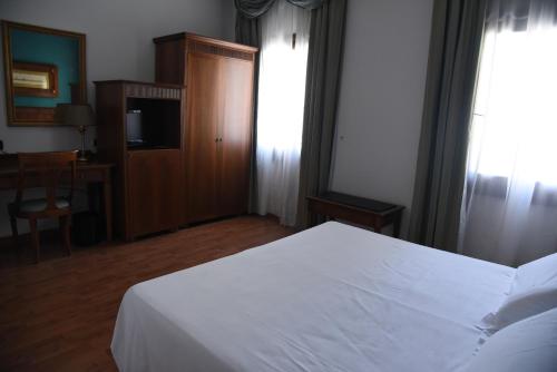 a hotel room with a white bed and a desk at HOTEL DUCA D'AOSTA in Mogliano Veneto