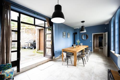 a dining room with blue walls and a wooden table and chairs at Penzion Pod hrádkem in Mikulov