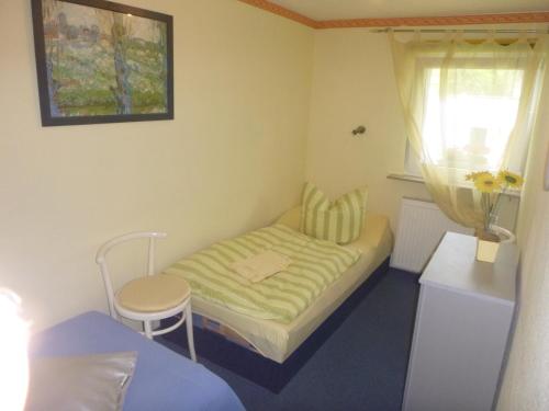 ein kleines Schlafzimmer mit einem Bett und einem Fenster in der Unterkunft Ferienhaus Görsdorf Berlin in Berlin