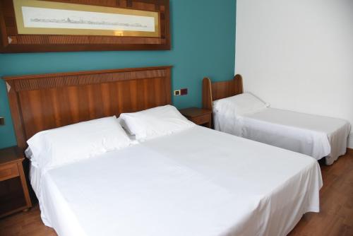 two white beds in a room with blue walls at HOTEL DUCA D'AOSTA in Mogliano Veneto