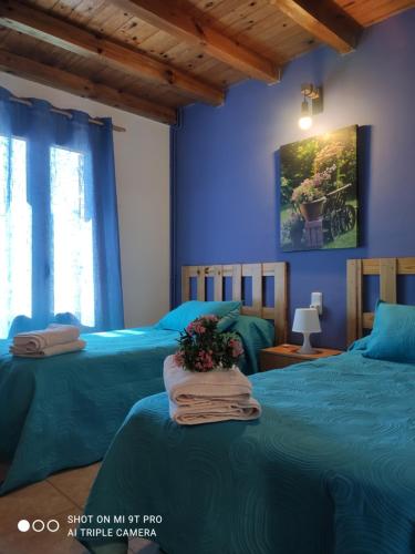 2 camas en una habitación con paredes azules en Apartamentos Goizeder, en Espinal-Auzperri