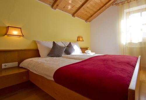 sypialnia z dużym łóżkiem i czerwonym kocem w obiekcie Zagler Appartments w mieście Tirolo