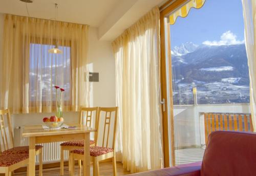 jadalnia ze stołem i dużym oknem w obiekcie Zagler Appartments w mieście Tirolo