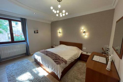 a bedroom with a bed and a table and a window at Cozy apartment in the Old Center of Prishtina in Pristina