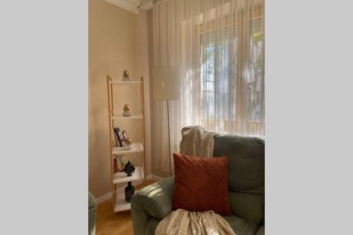 uma sala de estar com uma cadeira verde e uma janela em Cozy apartment in the center of Prishtina em Pristina