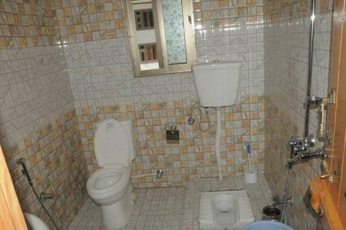 ein Bad mit einem WC und einem Spiegel in der Unterkunft Fridays Hotel in Shongran