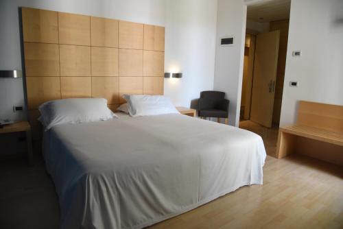a bedroom with a large white bed and a chair at HOTEL DUCA D'AOSTA in Mogliano Veneto