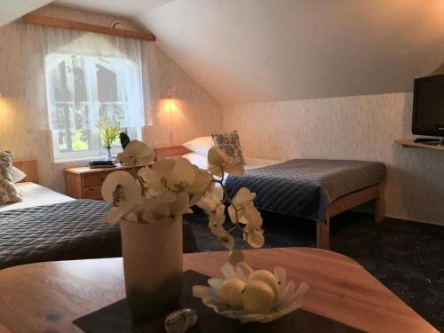 a hotel room with two beds and a table with flowers at Merekalda Accommodation - Adults Only in Käsmu