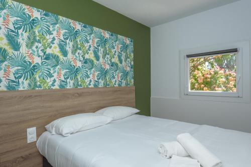 A bed or beds in a room at KYRIAD DIRECT TOULON OUEST - La Seyne sur Mer