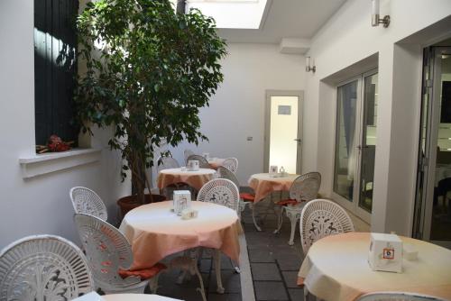 an empty restaurant with tables and chairs and a tree at HOTEL DUCA D'AOSTA in Mogliano Veneto